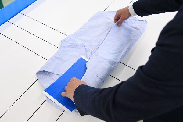 同じサイズでたためるよう、ガイドを引いた作業台とA4サイズ様の下敷き